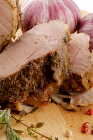 Slices of Grilled Pork Chop with Spices, Rosemary and Garlic closeup on Cutting Boardの写真素材