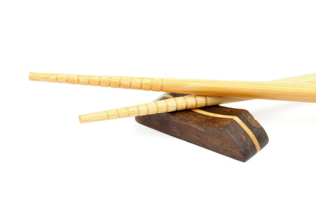 Pair of Beige Chopsticks and Brown Hasioki Cross Section on white backgroundの写真素材
