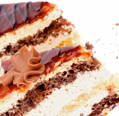 Pieces of Delicious Layered Cake with  with Glazed Cream and Grated Chocolate closeup on white backgroundの写真素材