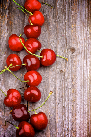 Red Ripe Sweet Cherries In a Row on Rustic Wooden backgroundの写真素材