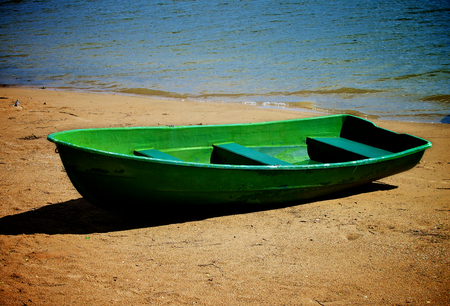 Old Lonely Green Boat on Sand River Shore Outdoorsの写真素材