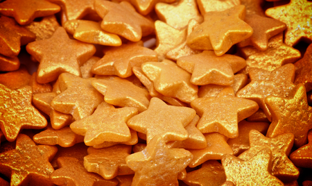 Background of Golden Sugar Stars Dessert Toppings closeup. Focus on Centreの写真素材