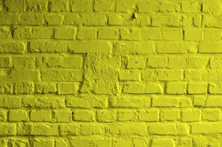 Background of Brick Wall Painted with Mortar Yellow Lemon Color closeupの写真素材