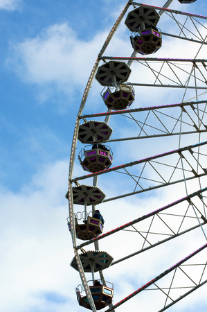 White and Pink Ride Ferris Wheel on Blue Cloudy Sky background Outdoorsの写真素材