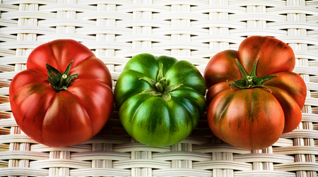 Red, Green and Orange Raw Ripe Tomatoes with Stems closeup on White Wicker background. Sort Fields Rafの写真素材