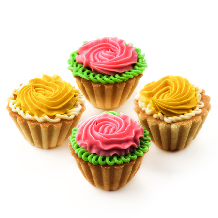 Arrangement of Delicious Little Tarts with Colored Butter Cream and Decoration closeup on White backgroundの写真素材