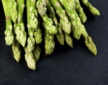 Heap of Fresh Asparagus Sprouts closeup on Black Slate backgroundの写真素材