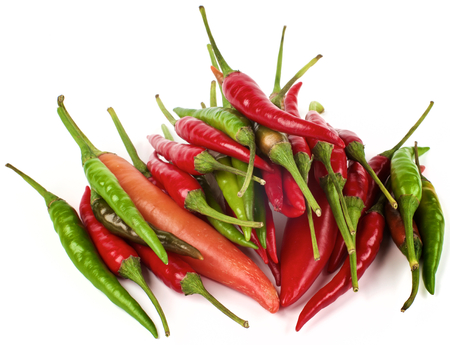 Stack of Various Perfect Red, Orange and Green Hot Chili Peppers closeup on White backgroundの写真素材