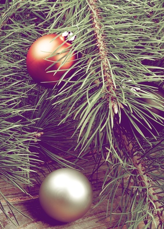 Christmas Decoration with Orange and Silver Baubles into Fluffy Green Pine Branches closeup on Wooden background. Retro Styledの写真素材