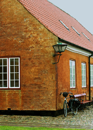 Alone Bicycle Waiting for near Old Red Brick House and Bench closeup Outdoors