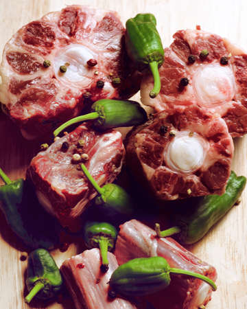 Fresh Raw Bull Oxtails with Pimiento Peppers closeup on Wooden background. Selective Focusの写真素材