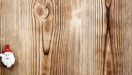 New Year Theme with Small Face of Santa in Red Hat closeup on Wooden Plank backgroundの写真素材