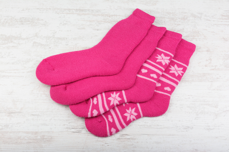 Pink woolen socks on white wooden backgroundの写真素材