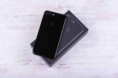 BURGAS, BULGARIA - DECEMBER 29, 2016: New Apple iPhone 7 Plus Jet Black, back side, on white wooden background.のeditorial素材