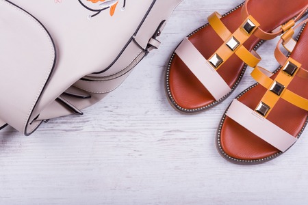 Fashionable women's sandals and backpack on white wooden background.の写真素材