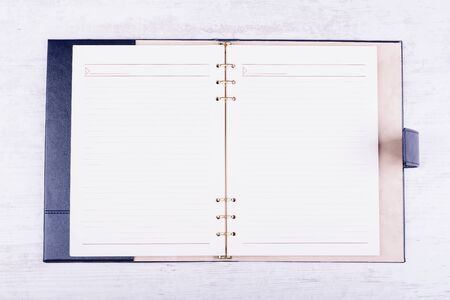 Opened leather notebook on white wooden backgroundの写真素材