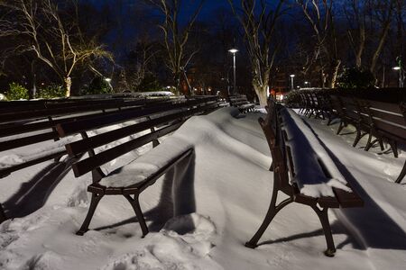 Winter landscape from Burgas Sea Garden, near the Culture center Sea Casino at blue hour, Bulgaria. Benches covered with snow.の写真素材