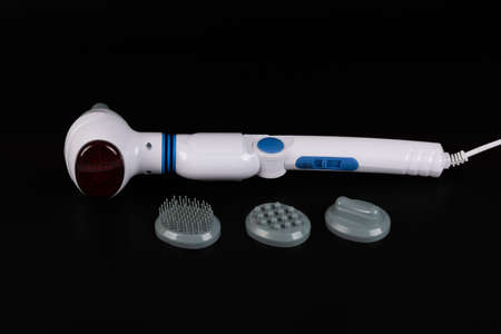 Electric infrared massage machine for the whole body and various attachments on a black background.の写真素材
