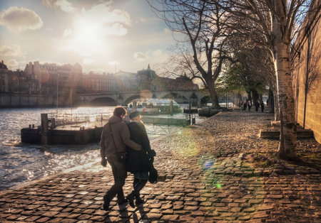 France, Paris - March 2008: Couple walks on the quai des Tuileries at sunsetのeditorial素材