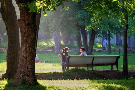 Russia, Moscow - Summer 2008: Two women sit on a bench in the park in the summerのeditorial素材