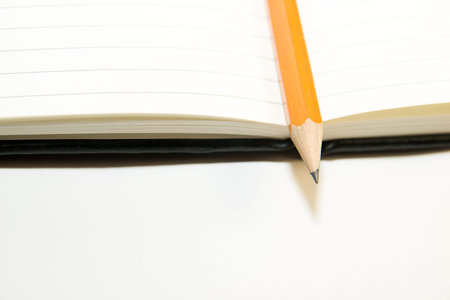 Notepad with a recording sheet and pencil  on a white backgroundの写真素材