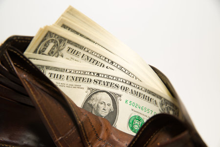 Old leather wallet with banknotes of US dollars inside