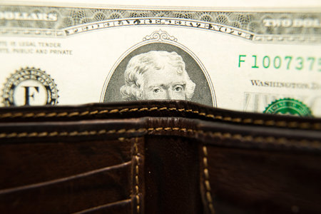 Old leather wallet with banknotes of US dollars insideの写真素材