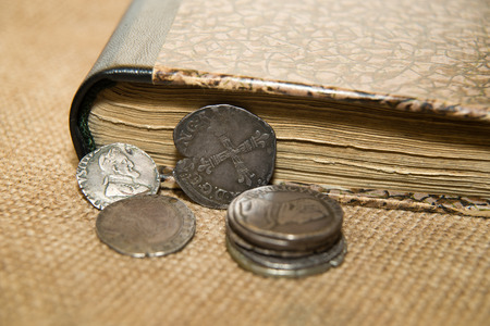 A lot of old French silver coins with portraits of kings on the old clothの写真素材
