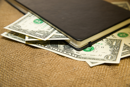 notebook with a blank sheet and money on the old tissueの写真素材