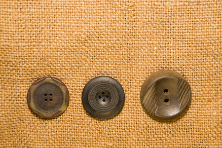 A lot of old buttons scattered on the old clothの写真素材