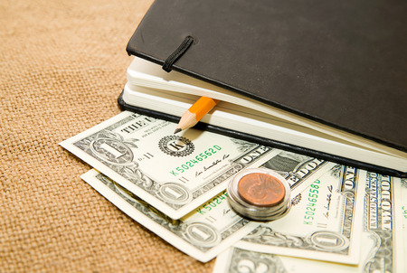 notebook with a blank sheet, pencil and money on the old tissueの写真素材
