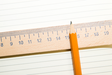 Notepad with a recording sheet, pencil and wooden ruler on the old tissueの写真素材