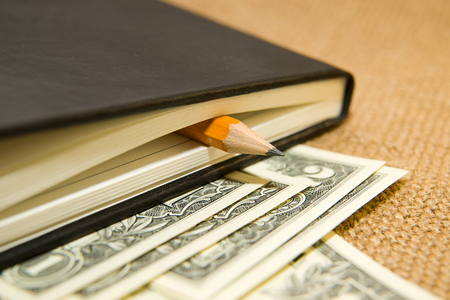 notebook with a blank sheet, pencil and money on the old tissueの写真素材