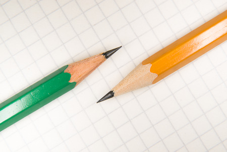 Opened notebook with a blank sheet and pencils on over whiteの写真素材