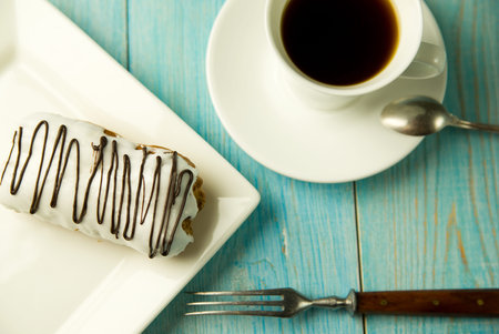 Cup of coffee and sweet buns on blue