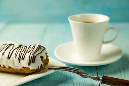 Cup of coffee and sweet buns on blue