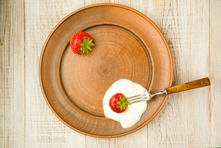 Ripe red strawberries on a brown plateの写真素材