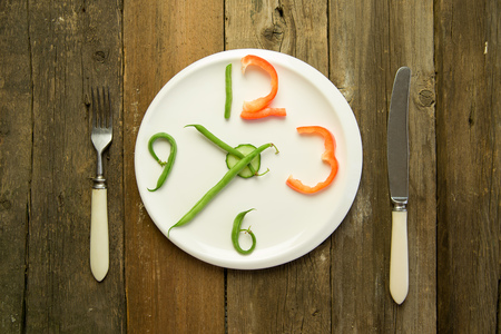 Watch made from vegetables are on a white plateの写真素材