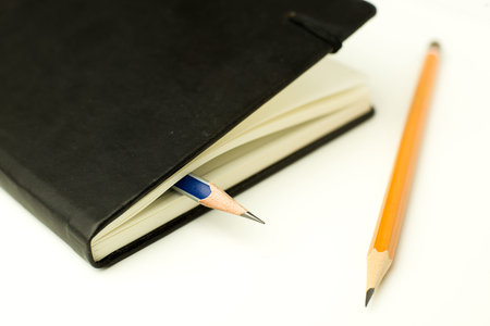 Diary and pencils on white
