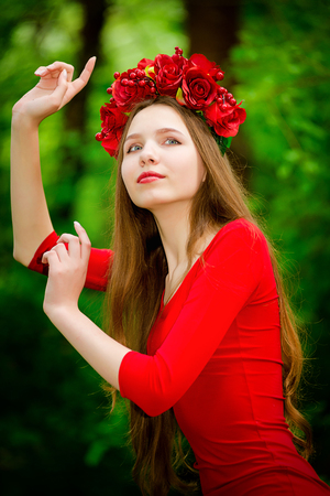 Young girl in wreath in the forest in summerの写真素材