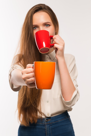 Young beautiful smiling girl holding a cupの写真素材
