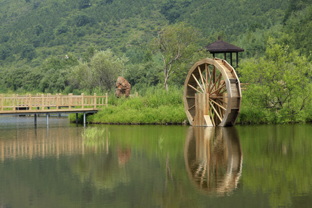 The reservoir in the mountains, has a wood water wheel, is very beautifulの写真素材