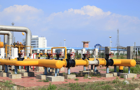 In oil field, there is oil pipeline and oilfield equipment at workの写真素材