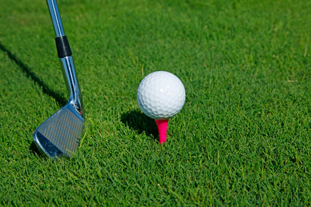 Golf club and ball in grassの写真素材