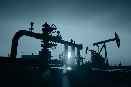 Oil field scene, Oil pipeline and pumping unit of the silhouetteの写真素材