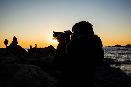 Woman taking pictures at the seaside