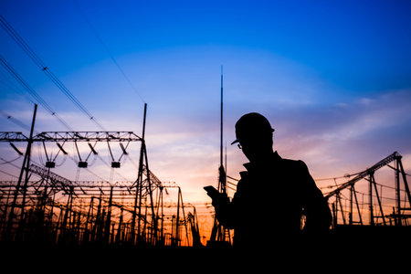 Electricity workers and pylon silhouette