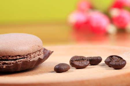 Macaroons and coffee beans on wooden tableの写真素材