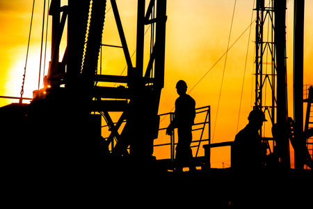 In the eveningï¼oil field, the oil workers are workingの写真素材