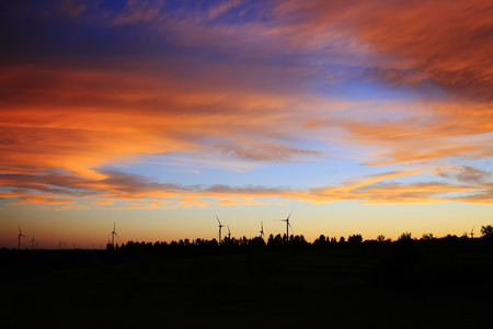 View of wind turbines in silhouette during sunsetの写真素材